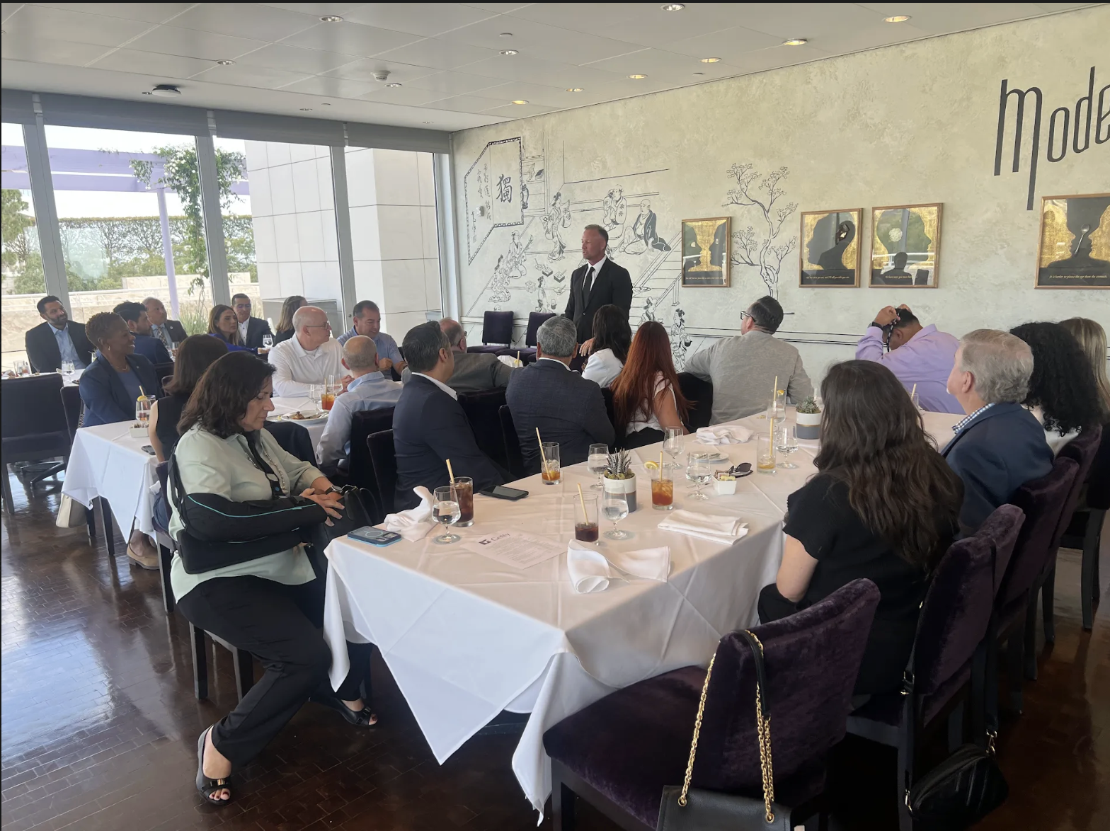 Photo of attendees sitting at a table listening to CCMF President Ken Striplin speak.